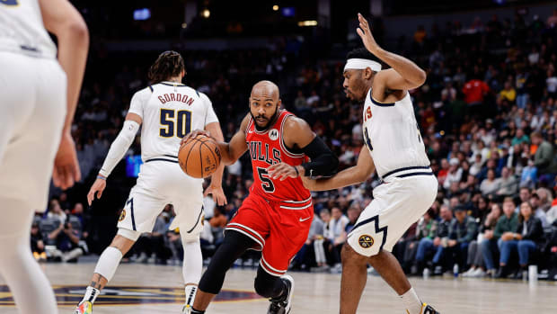 Chicago Bulls guard Jevon Carter (5) controls the ball against Denver Nuggets guard Jalen Pickett (24) in the first quarter at Ball Arena.